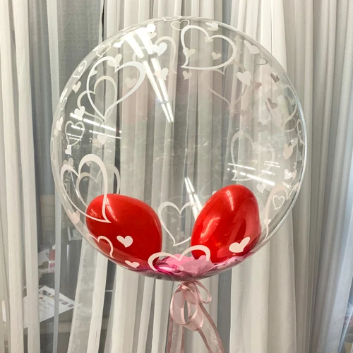 two small heart balloons inside clear balloon