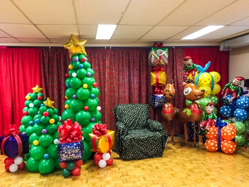 Balloon Christmas trees and gifts around Santa