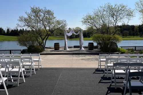 birch arch with organza draping, and chairs with padded seats for outdoor wedding