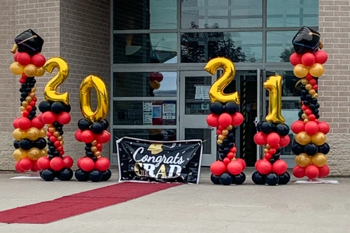 red and gold graduation decor with year in gold foil balloons