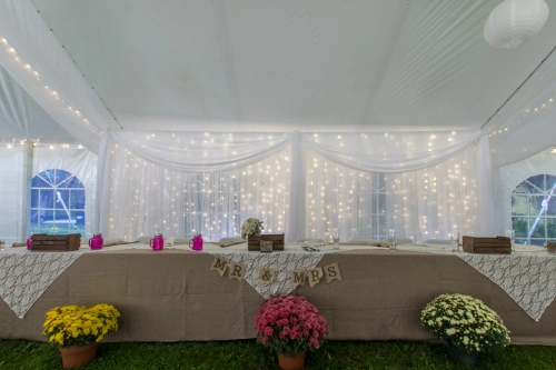 head table with burlap tablecloth and organza backdrop with lights
